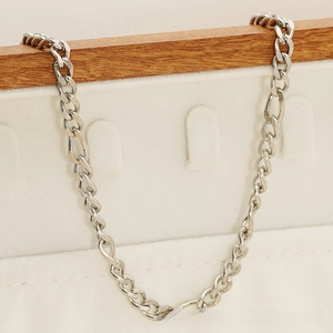 Macro view of silver-tone stainless steel Figaro chain links with polished finish