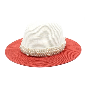 Detailed texture of two-tone woven straw hat with multiple rows of white pearls