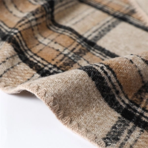 Close-up of brown and beige plaid scarf showing soft fabric texture and stitched edges
