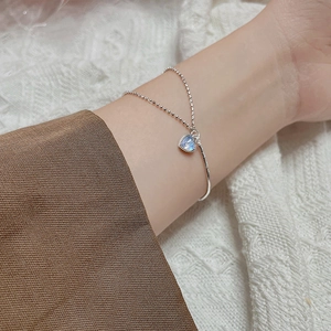 Chic double-layer silver bracelet with heart-shaped moonstone pendant on female wrist