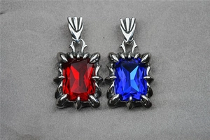 Detailed close-up of dragon claw pendants with red and blue gemstones in silver finish