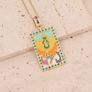 Macro shot of 18K gold tarot necklace featuring colorful enamel and green micro zircons