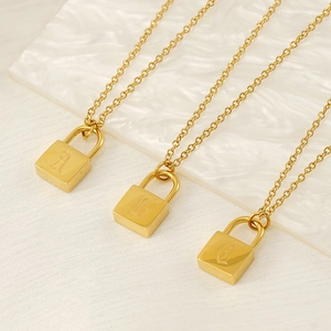 Vue détaillée des pendentifs cadenas dorés avec gravure des lettres alphabet A, B et C