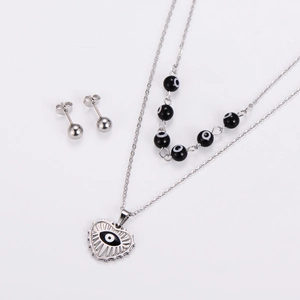 Detail of silver stainless steel jewelry set with black evil eye heart pendant and studs