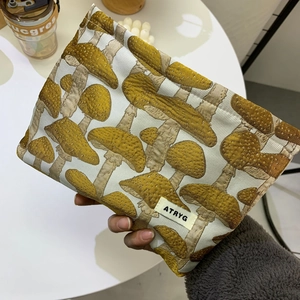 Portable jacquard mushroom pattern cosmetic travel bag in tan with ATRYG label