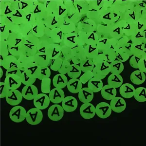 Macro shot of luminous acrylic flat round alphabet beads with black letter A for DIY jewelry