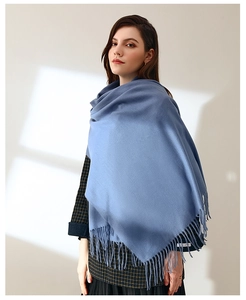 Detail of sky blue fringe scarf with soft cashmere-like texture and elegant drape