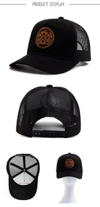 Detail view of black mesh trucker hat with brown round patch and adjustable snapback