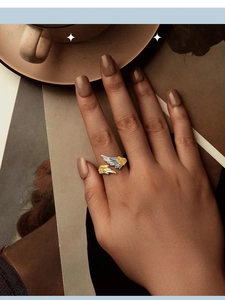 Detailed view of dual-tone 14K gold plated silver wing open ring worn on hand