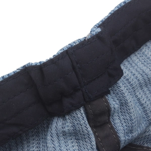 Close-up of blue denim newsboy cap featuring detailed stitching and premium wash texture