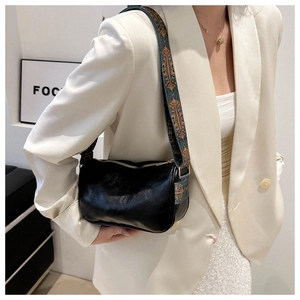 Detail of black soft leather crossbody bag with ethnic blue pattern wide shoulder strap