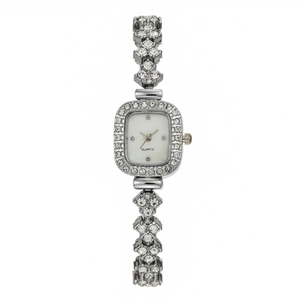Macro shot of silver square watch for women featuring pavé crystals and white quartz dial