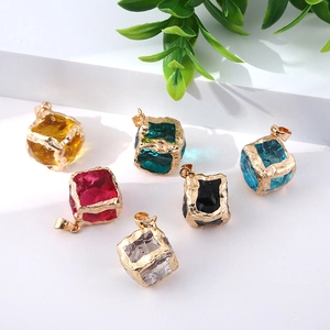 Colorful crystal cube pendants with gold plated irregular edges on white background