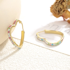 Close-up of gold heart hoop earrings featuring vibrant colorful crystal rhinestones