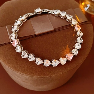 Gros plan d'un bracelet de tennis cœur en zircon étincelant sur un écrin en velours