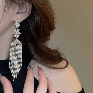 Close-up of flower stud earrings with long tassel fringes and sparkling zircon crystals