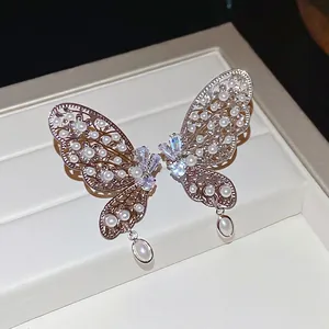 Clips d'oreilles papillon évidés avec perles blanches et zircons brillants en argent