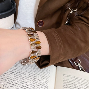 Close-up of amber teardrop bracelet on wrist with elegant vintage silver metal details