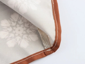Detail shot of coconut tree print fabric with stitched edges and textile texture