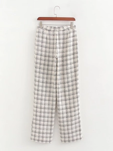 Detailed view of women's tweed wide-leg trousers featuring cream and black plaid pattern