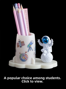 Detail of creative astronaut desk organizer with rocket pencil holder and moon ornament