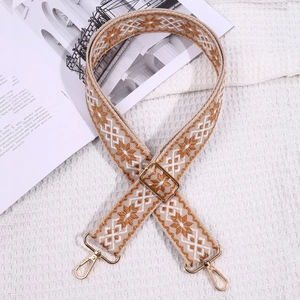 Close-up of geometric woven replacement bag strap in beige and brown with gold hardware