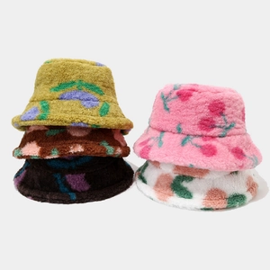 Flat lay of multiple colorful floral plush bucket hats in soft faux fur textures