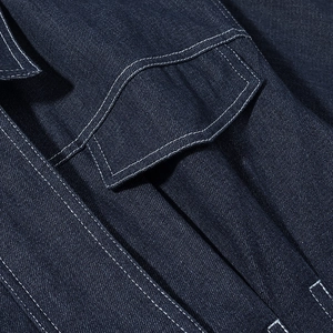 Detail of dark blue denim jacket showing premium white contrast stitching on pocket