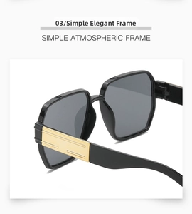 Close-up of black square frame sunglasses with elegant gold hinge detail and grey lenses