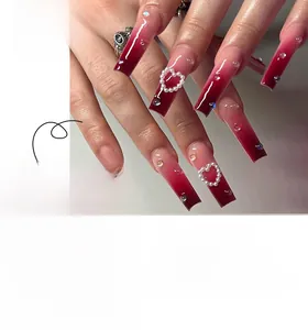 Detail of gradient burgundy press-on nails featuring pearl hearts and colorful rhinestones