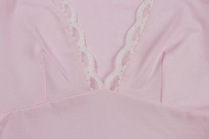 Detail of pink V-neck top showing delicate white lace trim and fitted sewing darts