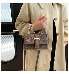 Detail showing leopard print texture and brown leather stitching on women's tote bag
