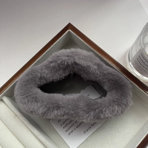 Close-up of a fluffy gray plush scrunchie displayed in a wooden jewelry box