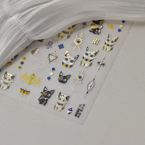 Detail of gold foil Egyptian cat nail stickers with Eye of Horus and geometric patterns