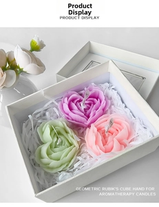 Detail shot of heart-shaped rose scented candles in pastel colors within a gift box