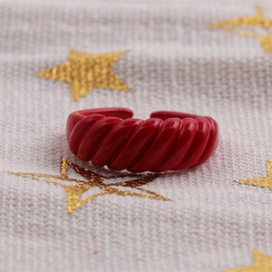 Macro shot of red glossy enamel twisted open ring with candy color croissant style finish