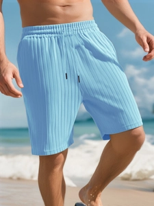 Close-up of light blue pleated texture and drawstring waist on men's beach shorts