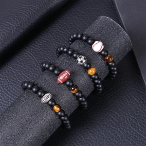 Detail of four matte bead bracelets with soccer and rugby charms on a display stand