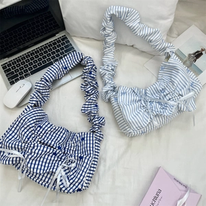 Detail of blue striped and checkered tote bags with pleated straps and ribbon bows