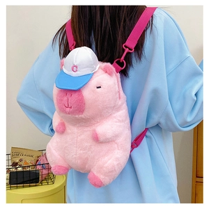 Detail of pink plush capybara backpack with C-letter baseball cap on a model