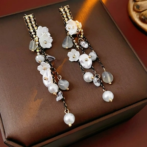 Elegant flower tassel earrings with pearls and crystals on a luxury leather jewelry box