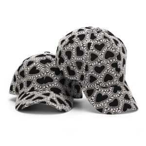 Retro baseball cap with black heart embroidery and white geometric stitching on cotton fabric