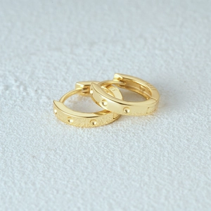 Detail of S925 hallmark on gold plated sterling silver earrings with textured surface