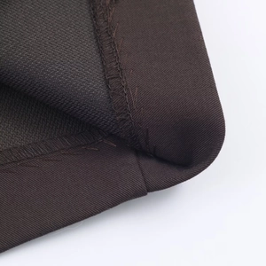 Gros plan sur la texture du tissu marron foncé et les coutures d'un costume décontracté
