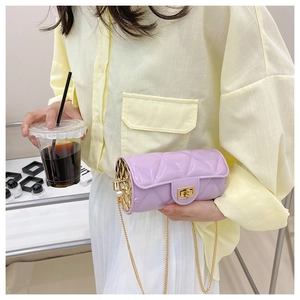 Detailed shot of purple quilted cylinder bag with gold chain strap and pearl decor