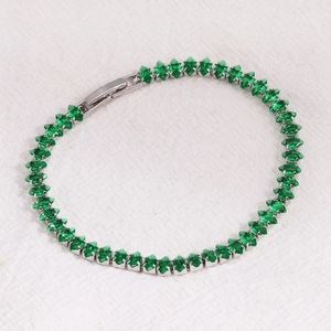 Detail of silver tennis bracelet with marquise-cut emerald green cubic zirconia stones