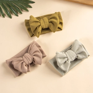 Three-piece set of knitted baby headbands with large bows in mustard, pink and sage green