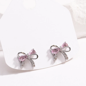 Detail von silbernen Schleifenohrringen mit rosa Zirkonia und 18K Vergoldung