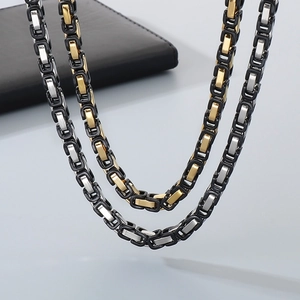Detailed close-up of a tricolor Byzantine chain necklace in black, gold, and silver finish