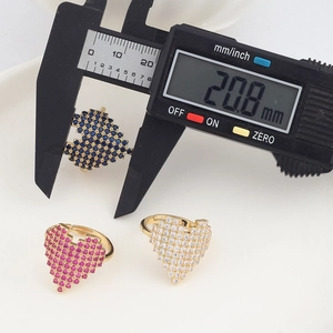 Close-up of heart-shaped pavé rings with adjustable gold bands and caliper measurement